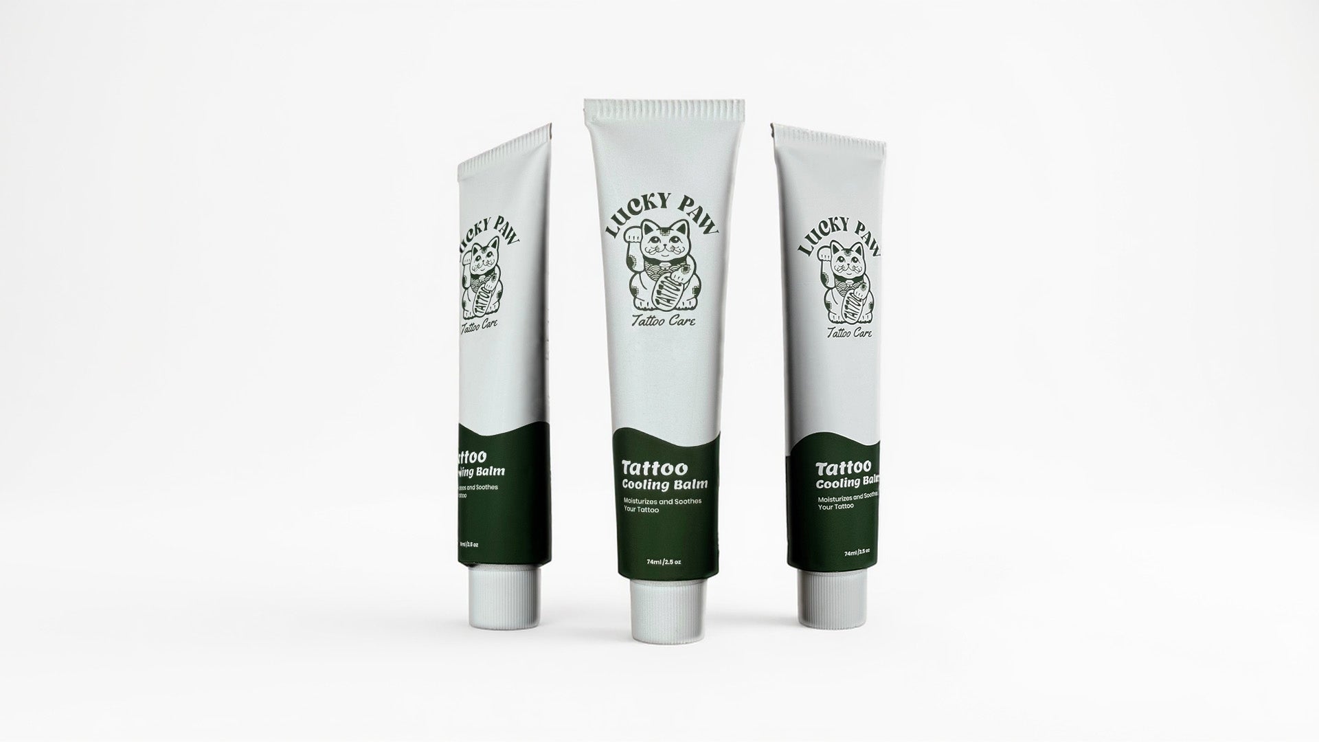 Three tubes of Lucky Paw Tattoo Cooling Balm standing upright on a white background, showing the Lucky Paw Tattoo Care logo and green label design.
